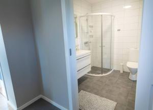 a bathroom with a shower and a sink and a toilet at Cozy and new apartment in Arendal -Hill in Arendal