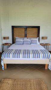 un grande letto con cuscini a righe blu e bianche di Alojamiento Reserva Natural La Maria ad Armenia