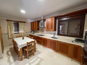 a kitchen with wooden cabinets and a table in it at VILLA en Playa La Barrosa in Chiclana de la Frontera