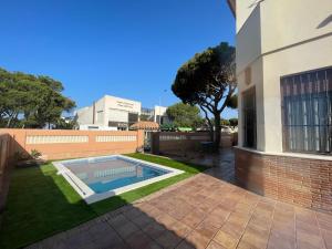 - une piscine dans une cour à côté d'un bâtiment dans l'établissement VILLA en Playa La Barrosa, à Chiclana de la Frontera