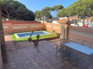 a patio with two tables and a swimming pool at VILLA en Playa La Barrosa in Chiclana de la Frontera