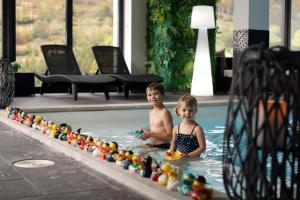 dos niños en una piscina con sus juguetes en Chalet Bellevue, en Ventron