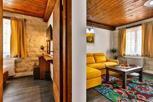 a living room with a yellow couch and a table at Stara Čaršija Hotel & SPA in Bar