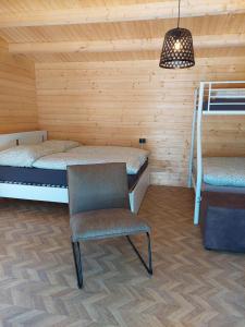 a room with two bunk beds and a chair at Camping-Aller-Leine-Tal in Engehausen