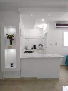 a white kitchen with a stove and a counter top at Appartement Fethia in Houmt Souk