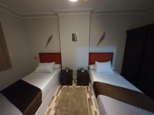 twee bedden in een kleine kamer met bij Youvala serviced apartment Giza in Caïro
