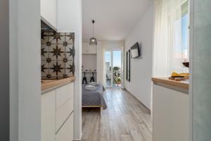 una cucina con pareti bianche e pavimenti in legno di Apartmani Luce Trogir a Trogir
