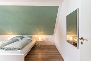 a bedroom with a bed and a green wall at Haus 23 in Ettenheim