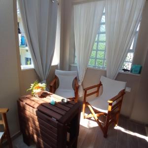 een kamer met een tafel en stoelen en een raam bij PERLA apartments in Paralia Dionysiou