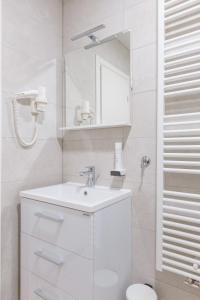 a white bathroom with a sink and a mirror at Stay Swanky Bed & Breakfast in Zagreb