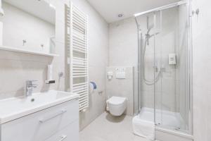 a white bathroom with a shower and a toilet at Stay Swanky Bed & Breakfast in Zagreb