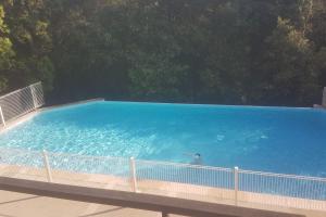 a person swimming in a large blue swimming pool at Villa dans un puits de verdure avec piscine résidentielle in Valbonne