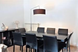 a dining room with a black table and black chairs at Villa dans un puits de verdure avec piscine résidentielle in Valbonne