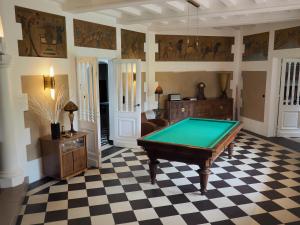a room with a pool table on a checkered floor at Manoir au coeur du triangle d or au Touquet in Le Touquet-Paris-Plage