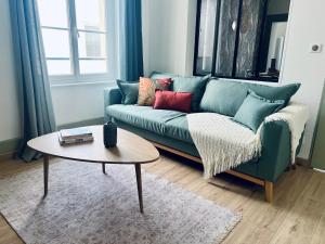 sala de estar con sofá verde y mesa en "Le Charleville", Superbe appartement, gare de Nevers, service premium by PRIMO C0NCIERGERIE en Nevers