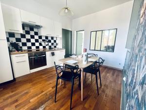 - une cuisine et une salle à manger avec une table et des chaises dans l'établissement "Le Charleville", Superbe appartement, gare de Nevers, service premium by PRIMO C0NCIERGERIE, à Nevers