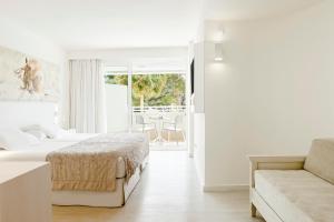 een witte slaapkamer met een bed en een bank bij Iberostar Cristina in Playa de Palma