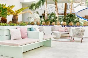 a lobby with a couch and chairs and palm trees at Iberostar Cristina in Playa de Palma