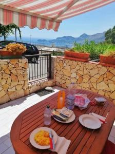 einen Holztisch mit Essen auf einer Terrasse in der Unterkunft An Eye on Taormina in Letojanni