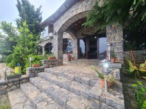 Casa de piedra con una escalera de piedra que conduce a un edificio en Hotel Kukesi en Pogradec