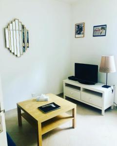 uma sala de estar com uma televisão e uma mesa de centro em Appartement 23 em Reims