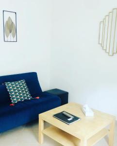 a living room with a blue couch and a coffee table at Appartement 23 in Reims