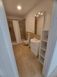 a bathroom with a sink and a toilet and a mirror at Apartments Pronavtik in Piran