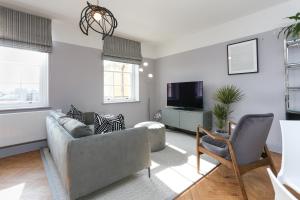 sala de estar con sofá y TV en Arlington House, Central Apartmant en Bath