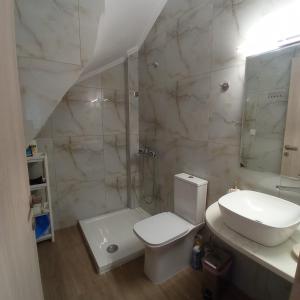 uma casa de banho branca com um lavatório e um WC em PERLA apartments em Paralia Dionysiou