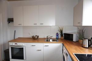 a kitchen with white cabinets and a sink at Ferienwohnung Oderwind in Oderberg