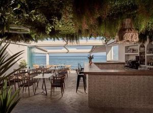 un ristorante con tavoli e sedie e l'oceano di Sanpiero Island a Città di Zante