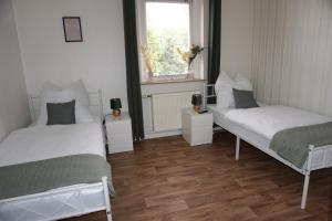 2 Betten in einem kleinen Zimmer mit Fenster in der Unterkunft Ferienwohnung Oderwind in Oderberg