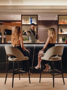 a man sitting at a bar talking to a woman at Hotel Du Lac in Limone sul Garda +78 photos
