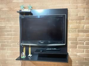uma televisão de ecrã plano sentada numa bancada preta em GV Apartamentos-2qt-area central nobre- ar cond- em Governador Valadares