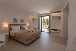 Paros Breeze Luxury Villa في دريوس: غرفة نوم بسرير كبير وبلكونة