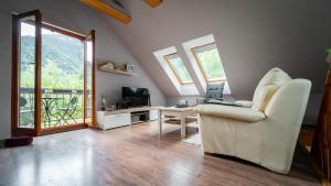 a living room with a white chair and a television at Holiday house Kajfes in Brod na Kupi