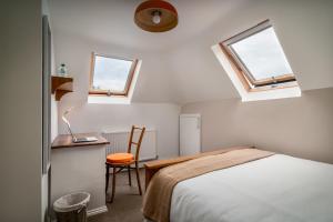 a bedroom with a bed and a desk and two windows at NO.18 in Harrogate