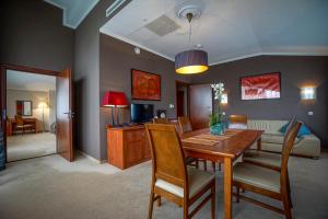 a dining room and living room with a table and chairs at Farmona Hotel Business & SPA in Kraków