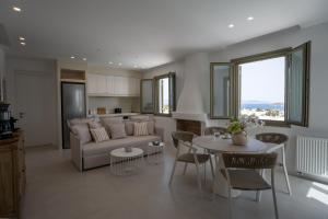 a living room with a couch and a table and chairs at Paros Breeze Luxury Villa in Drios