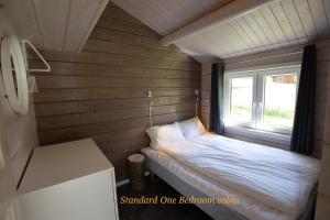 a small bed in a room with a window at Geirangerfjorden Feriesenter in Geiranger