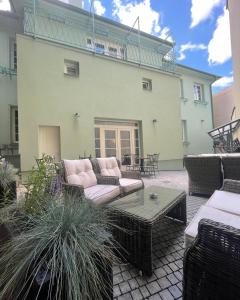 a patio with couches and a table in front of a building at Wellness Hotel Smaragd Piešťany in Piešťany