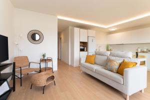 a living room with a couch and a kitchen at Apartamento Roca Paraíso Agaete vistas y jardín in Agaete