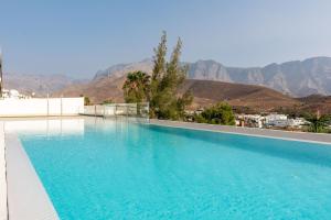 una piscina con montañas en el fondo en Apartamento Roca Paraíso Agaete vistas y jardín en Agaete