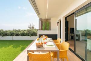 a dining room with a table and yellow chairs at Vivelorural Agaete great garden & pool in Agaete