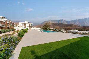 a view of a house with a lawn and a swimming pool at Apartamento Roca Paraíso Agaete vistas y jardín in Agaete