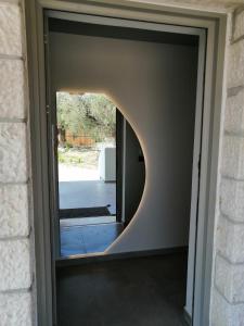 une porte avec une fenêtre ronde dans une maison dans l'établissement Black Pearl Apartment Lithakia Zakynthos, à Lithakia
