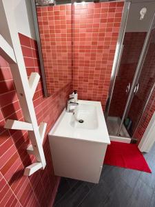 baño con lavabo blanco y azulejos rojos en A due passi da en Corato