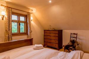 una camera con letto, cassettiera e finestra di Jotaferien Transylvanian Cottage with Fireplace 