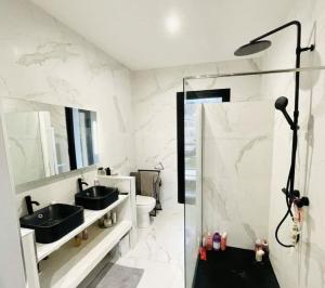ein Bad mit 2 Waschbecken und einer Dusche in der Unterkunft Villa proche Disneyland paris 5 chambres 