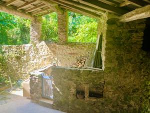 uma casa de pedra com uma janela e uma parede de pedra em Chambres et gîte en Cévennes em Cros